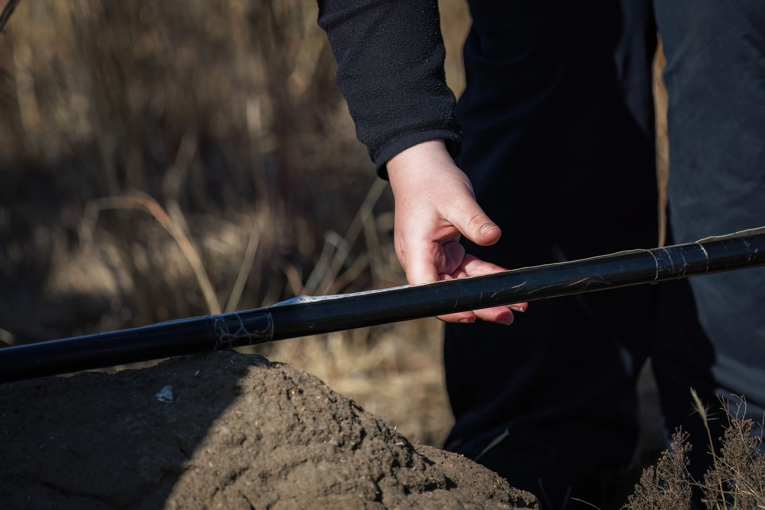 Technician handling grounding rod during field installation
